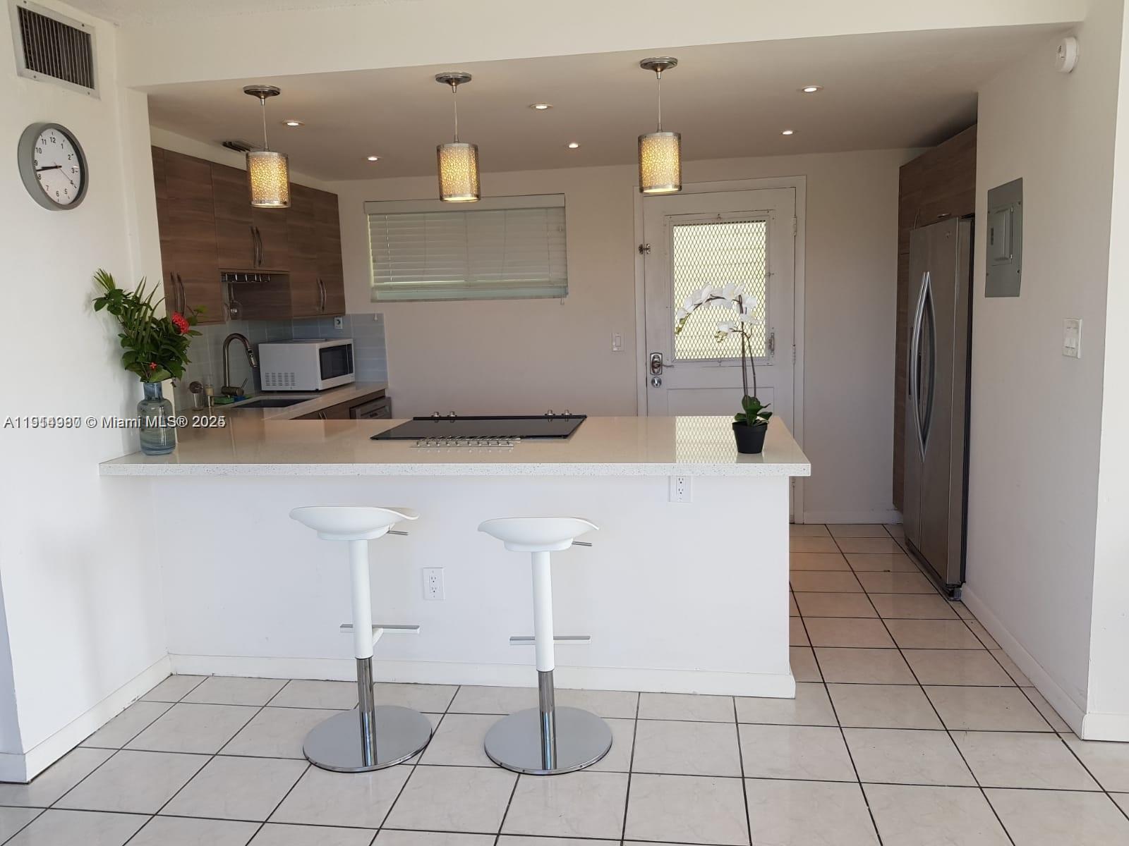 8001 Crespi Boulevard, Unit 6D Miami Beach, FL 33141 - Photo 6 of 29 a view of kitchen with granite countertop cabinets and white appliances