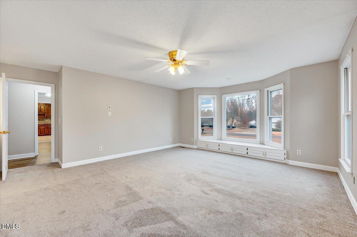 2805 Mary Marvin Trail Willow Spring, NC 27592 - Photo 15 of 33 an empty room with chandelier fan and windows