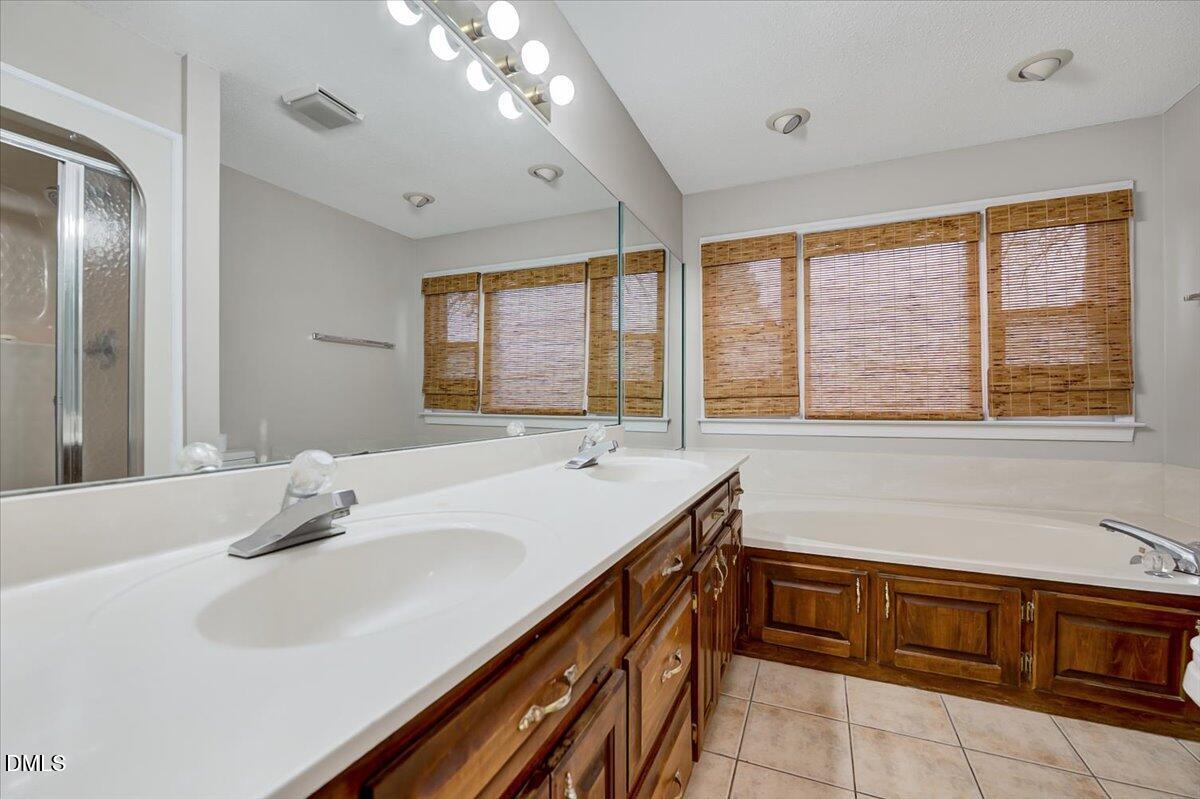 2805 Mary Marvin Trail Willow Spring, NC 27592 - Photo 17 of 33 a bathroom with a sink and a large mirror