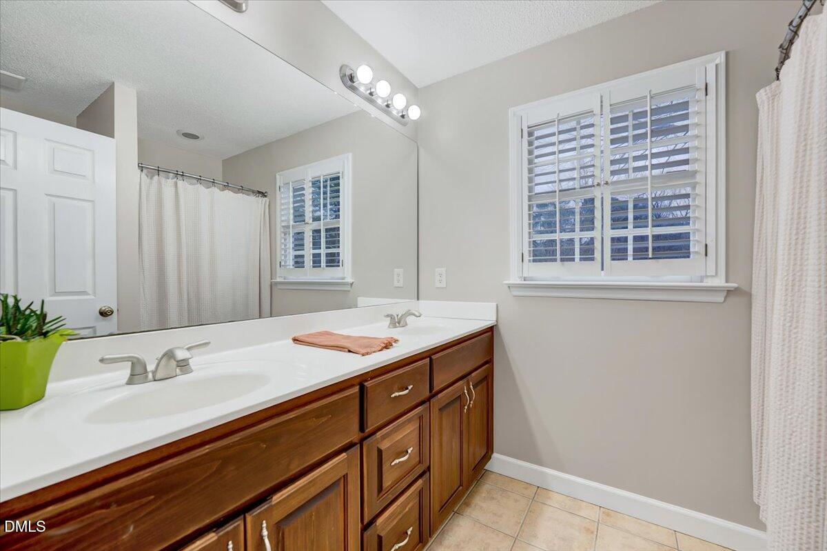 2805 Mary Marvin Trail Willow Spring, NC 27592 - Photo 20 of 33 a bathroom with a granite countertop sink and a mirror