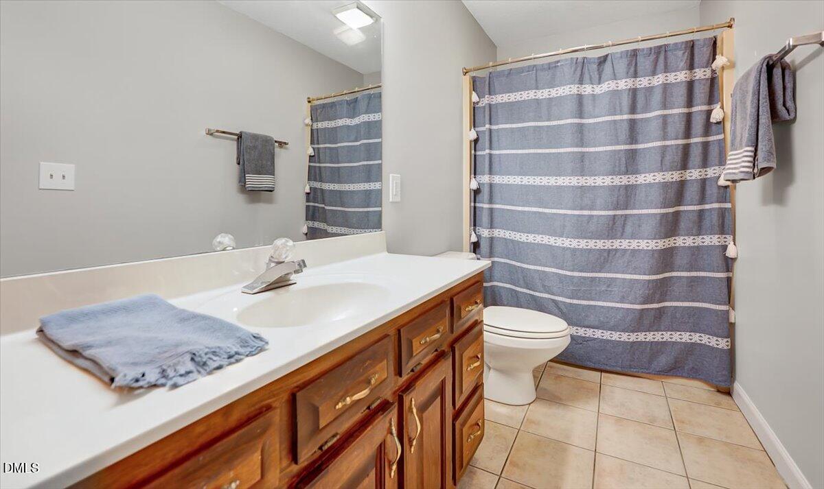 2805 Mary Marvin Trail Willow Spring, NC 27592 - Photo 24 of 33 a bathroom with a sink a toilet a shower and a mirror