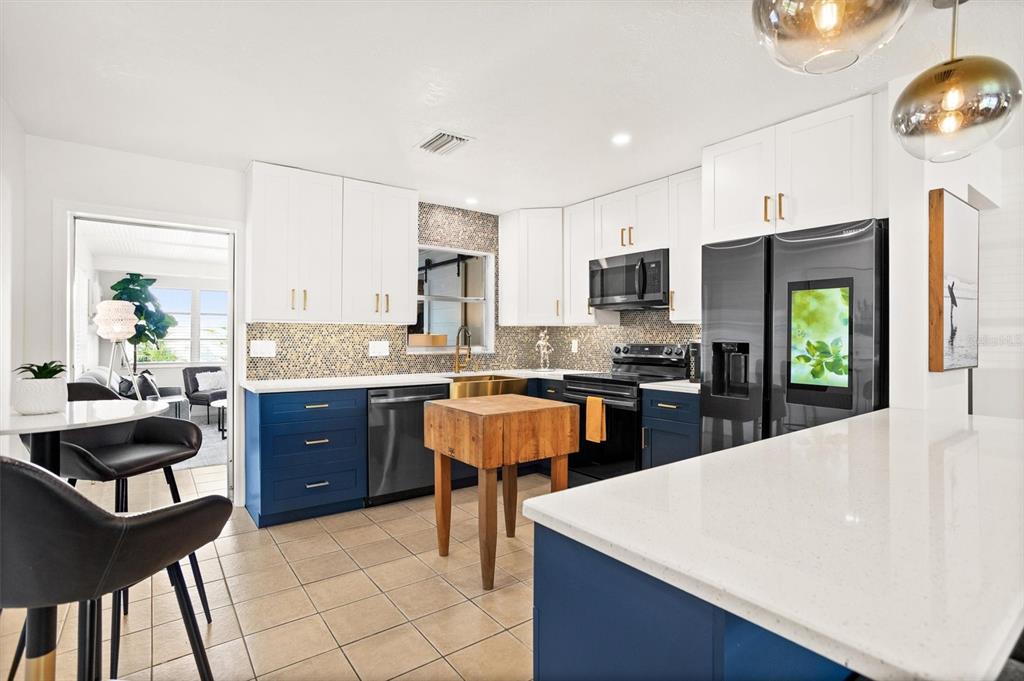 3488 40th Way North St. Petersburg, FL 33713 - Photo 10 of 70 a large kitchen with kitchen island granite countertop a stove a sink a dining table and chairs