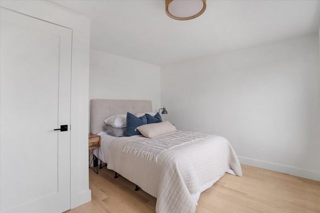 a bedroom with a bed and a white wall