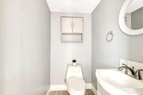 a bathroom with a toilet sink and mirror