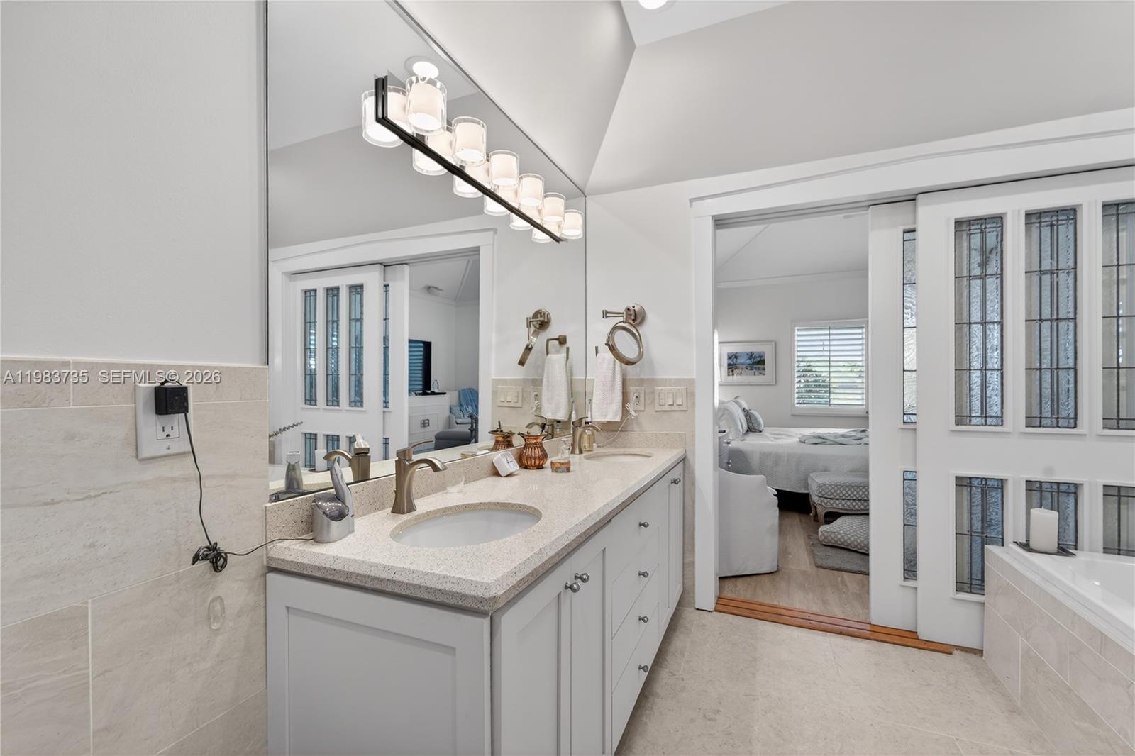 851 Saturn Street, Unit D Jupiter, FL 33477 - Photo 20 of 60 a bathroom with a double vanity sink a toilet and a mirror
