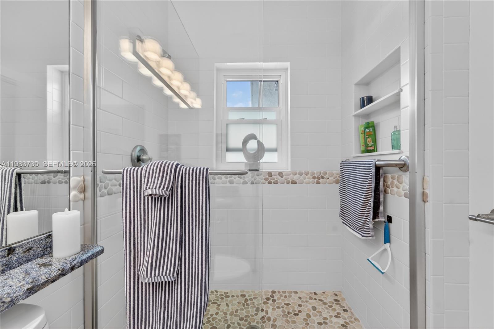 851 Saturn Street, Unit D Jupiter, FL 33477 - Photo 24 of 60 a bathroom with a granite countertop shower a sink and a mirror