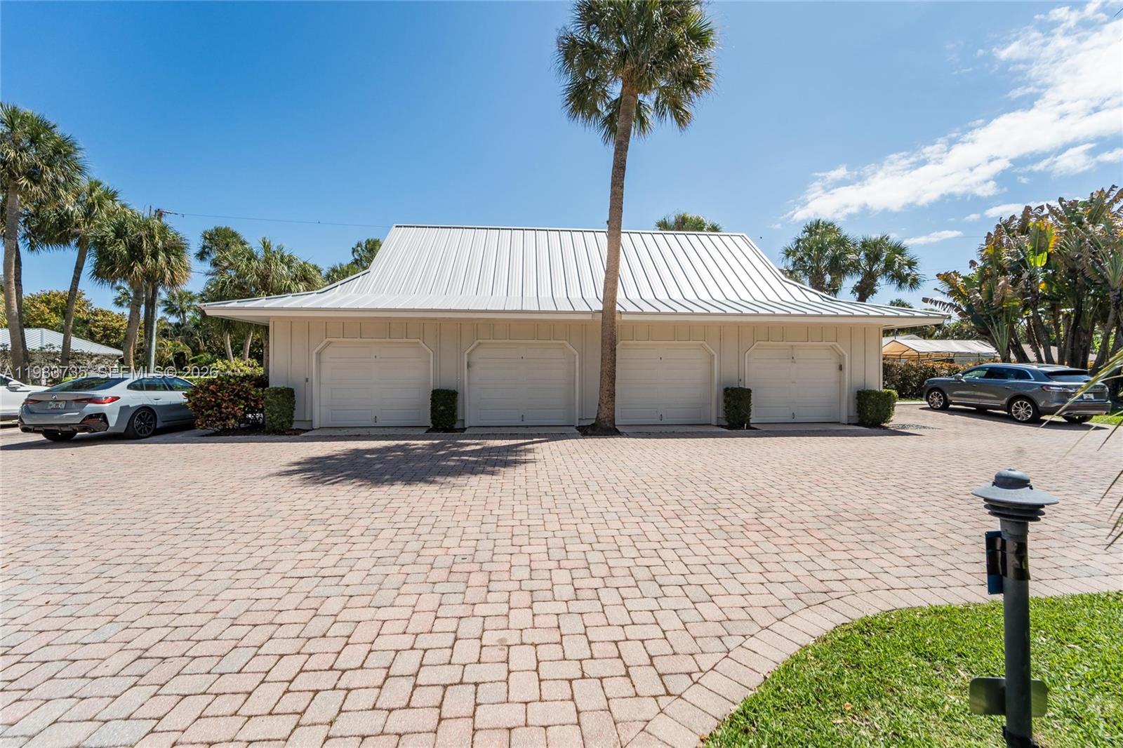 851 Saturn Street, Unit D Jupiter, FL 33477 - Photo 37 of 60 a front view of a house with a yard and garage
