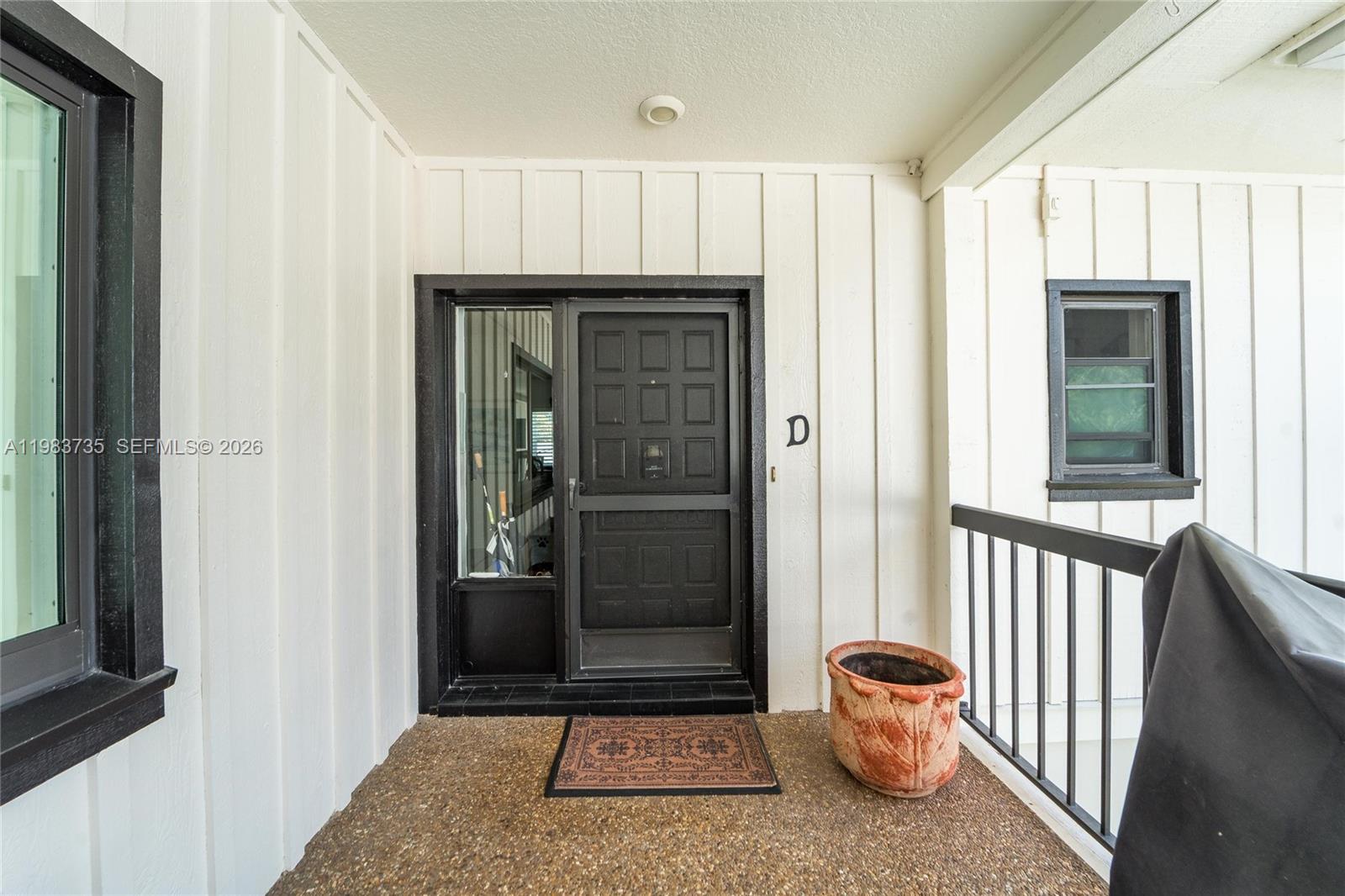 851 Saturn Street, Unit D Jupiter, FL 33477 - Photo 6 of 60 a view of a hallway with wooden floor and a cabinet