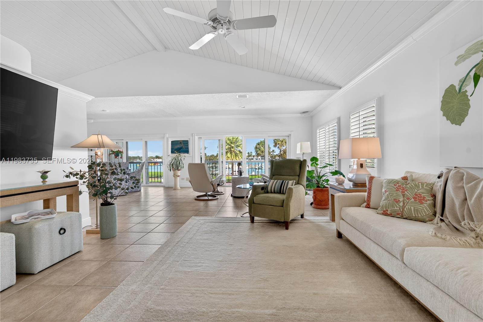 851 Saturn Street, Unit D Jupiter, FL 33477 - Photo 7 of 60 a living room with furniture and a flat screen tv