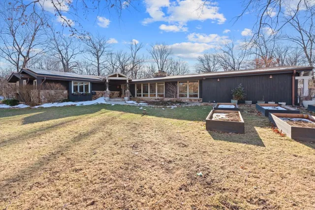 a view of a backyard with table and chairs under a large tree