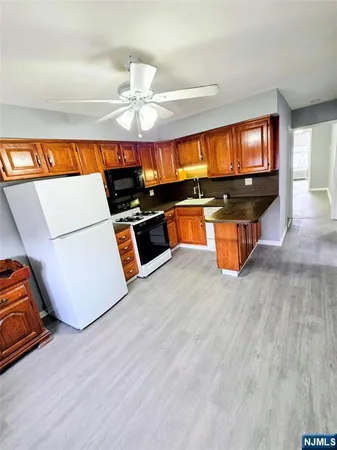 a living room with furniture a flat screen tv and kitchen view