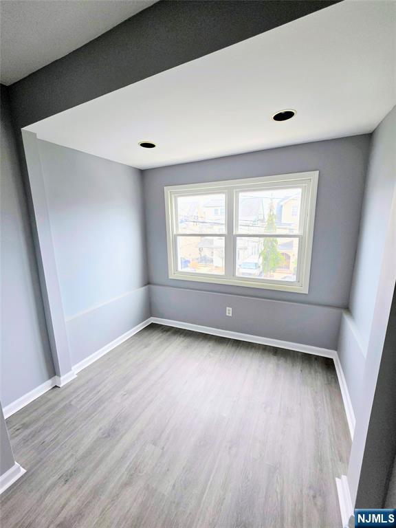 245 Beech Street, Unit 2 Kearny, NJ 07032 - Photo 10 of 16 a view of an empty room with wooden floor and a window
