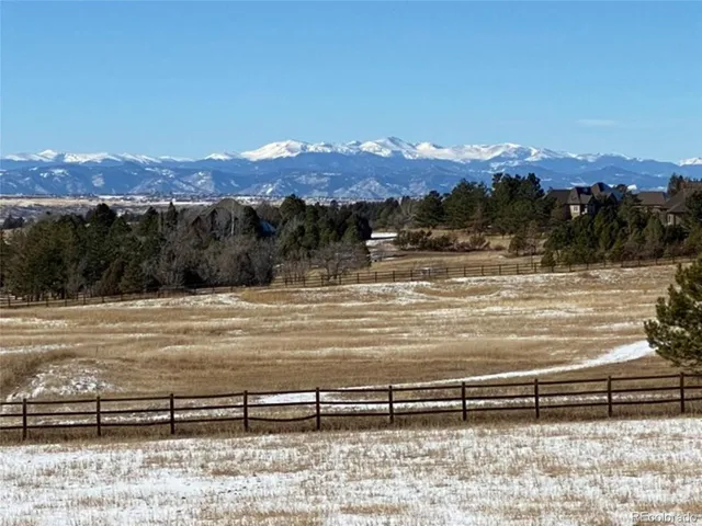 a view of a big yard with mountains in the background