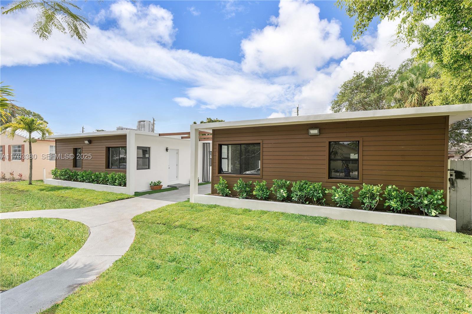 1946 Pierce Street, Unit 3 Hollywood, FL 33020 - Photo 2 of 43 a view of a house with a yard and a large tree