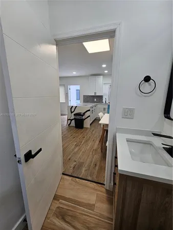 a kitchen with a refrigerator sink and wooden floor