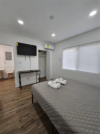 a bedroom with a bed and a flat screen tv