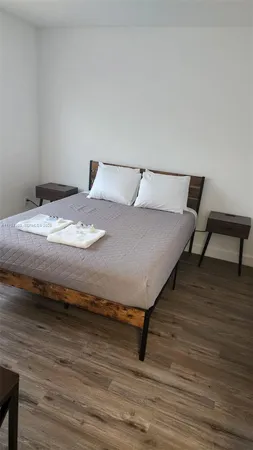 a bedroom with a bed and wooden floor
