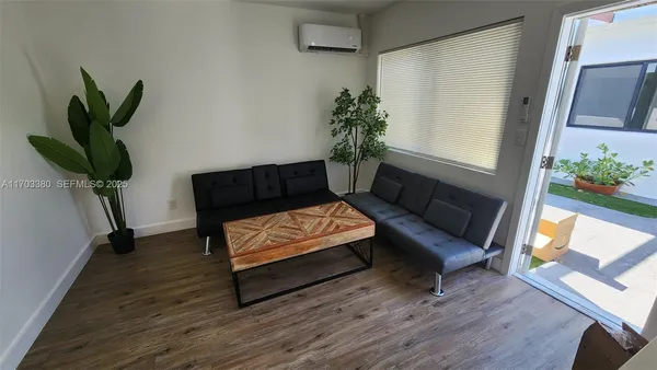 a living room with furniture plant and a window