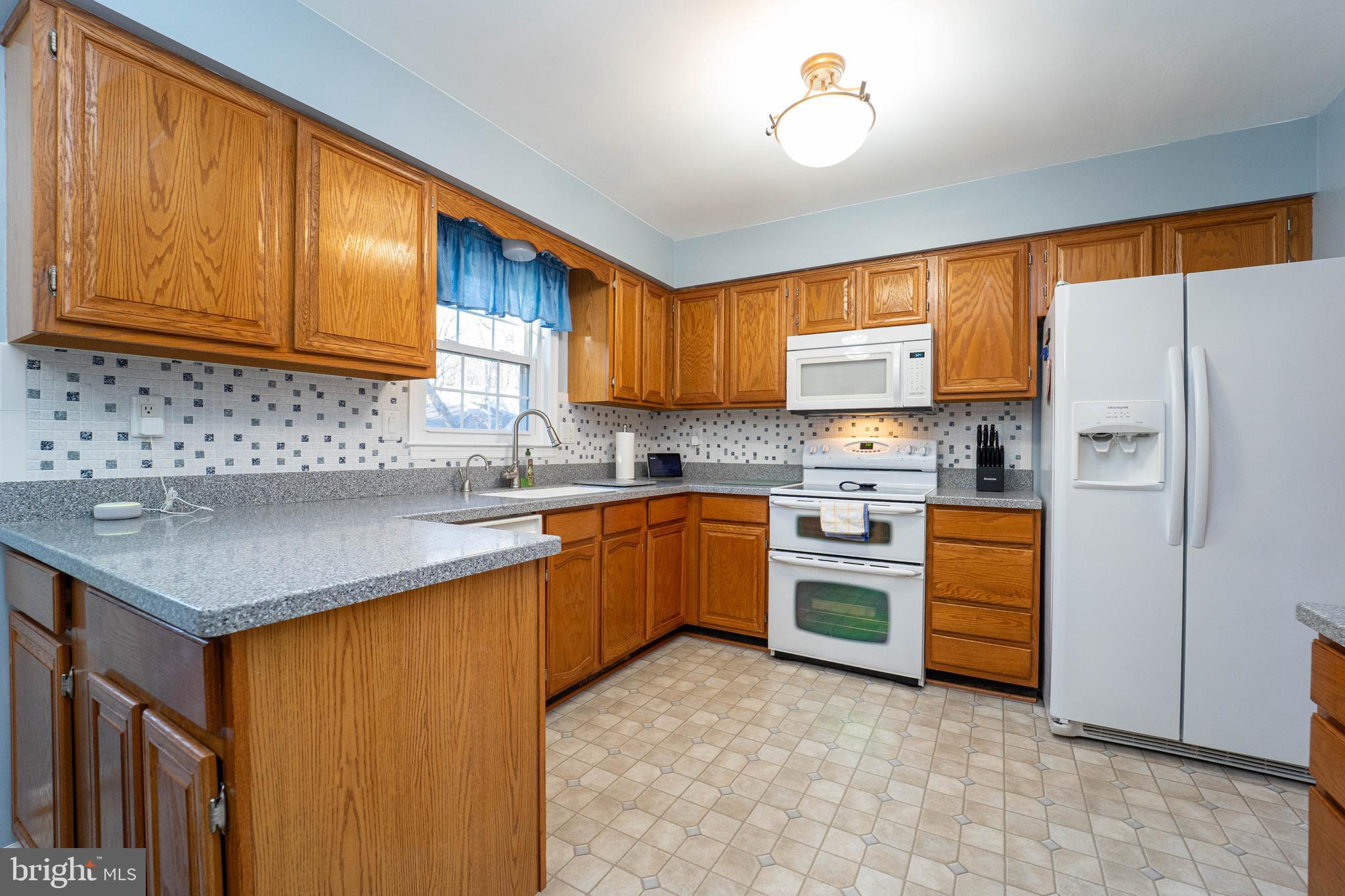10531 Hunters Way Laurel, MD 20723 - Photo 8 of 42 a kitchen with stainless steel appliances granite countertop a sink stove and refrigerator