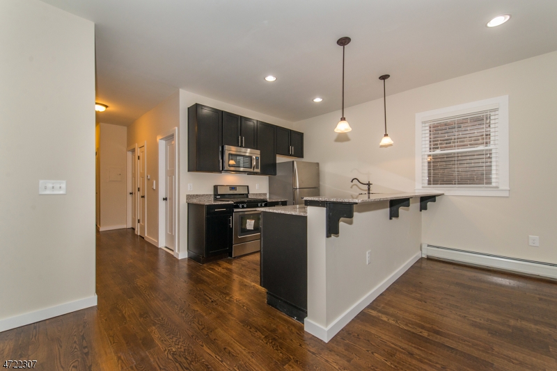 a kitchen with kitchen island white cabinets and stainless steel appliances