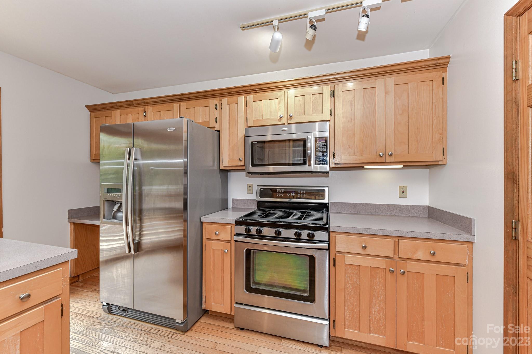 7911 Sims Road Waxhaw, NC 28173 - Photo 12 of 48 a kitchen with granite countertop a refrigerator stove and microwave