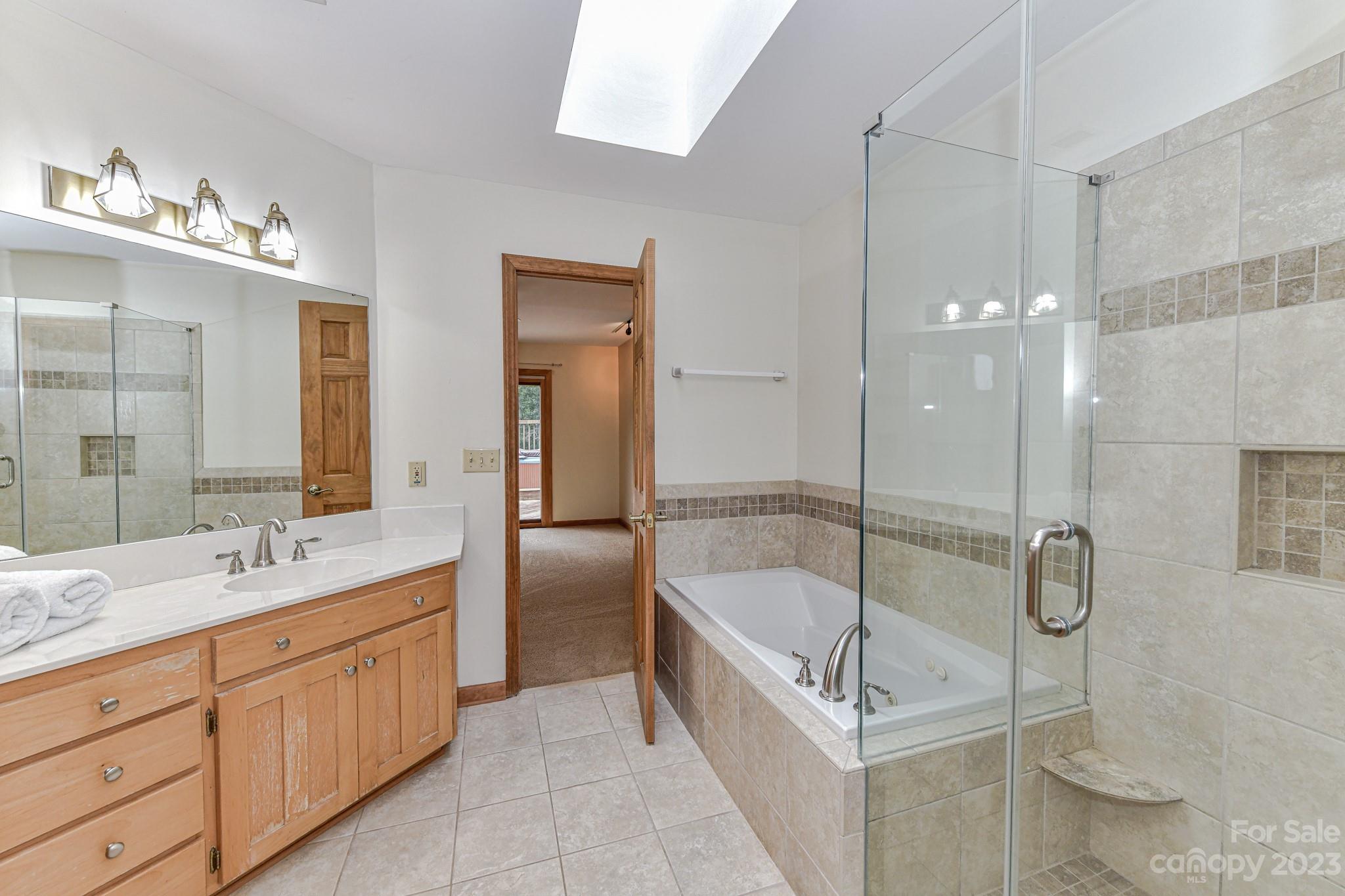 7911 Sims Road Waxhaw, NC 28173 - Photo 15 of 48 a bathroom with a tub sink a shower and mirror
