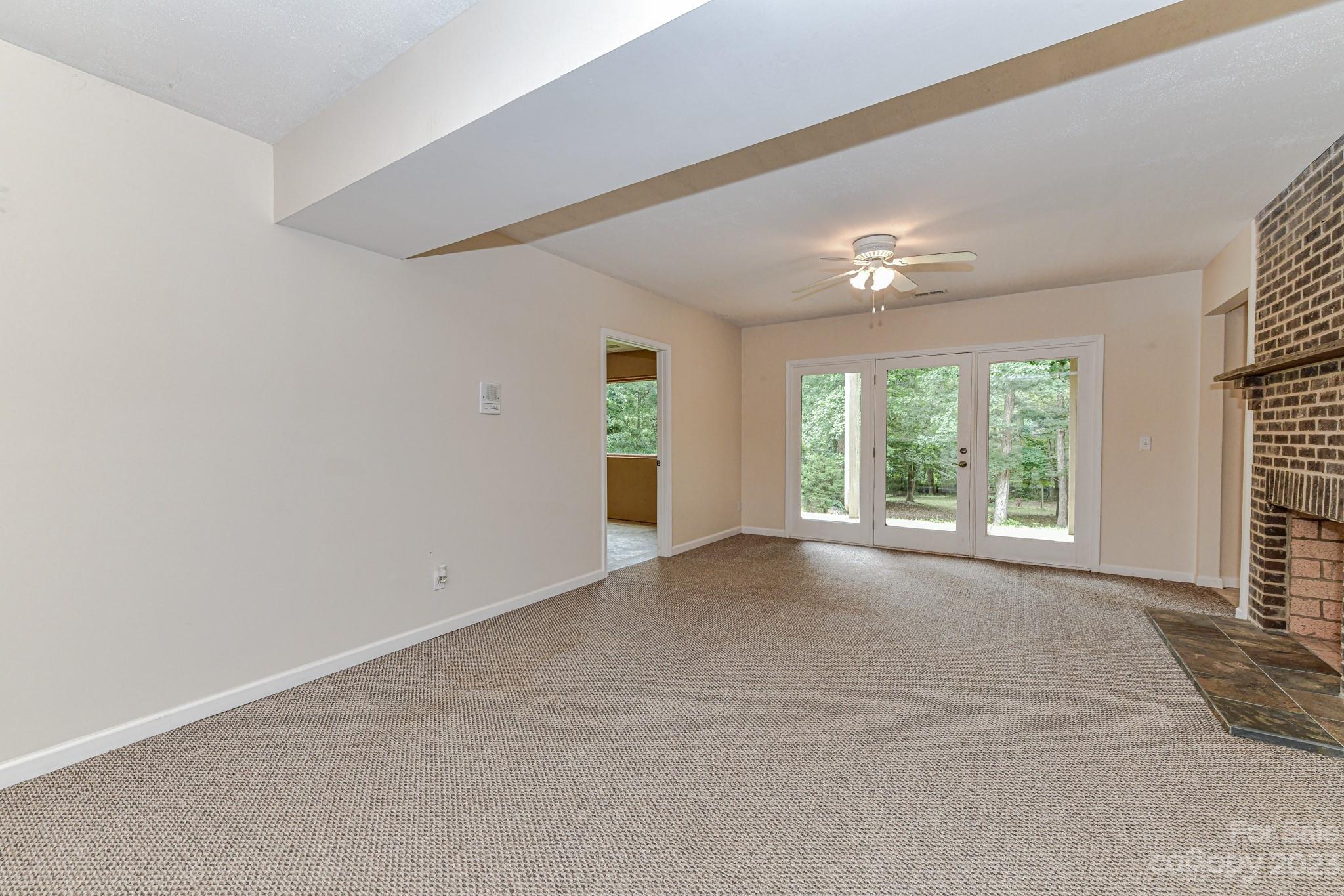 7911 Sims Road Waxhaw, NC 28173 - Photo 23 of 48 a view of a big room with windows and chandelier fan
