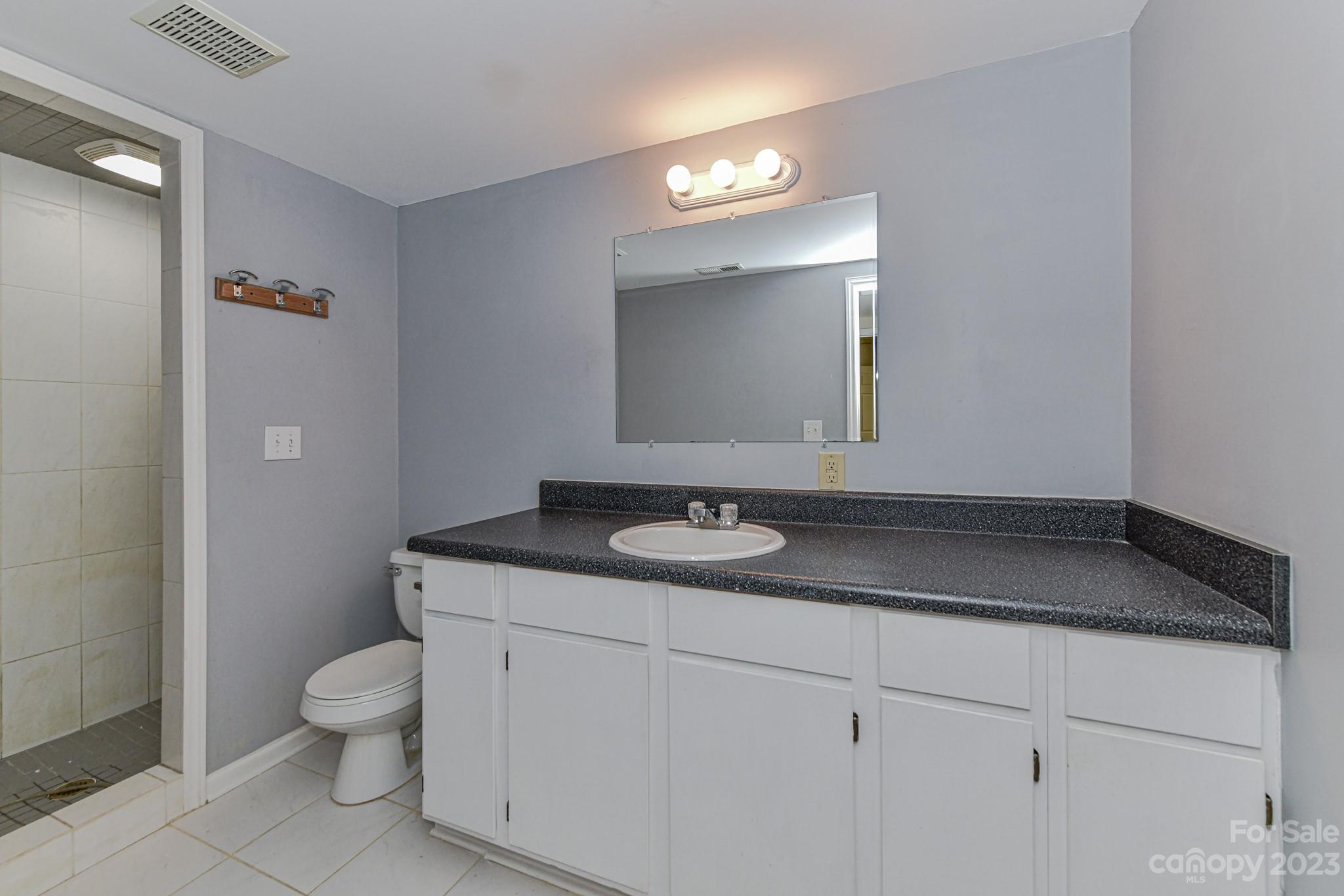 7911 Sims Road Waxhaw, NC 28173 - Photo 26 of 48 a bathroom with a granite countertop toilet sink and mirror