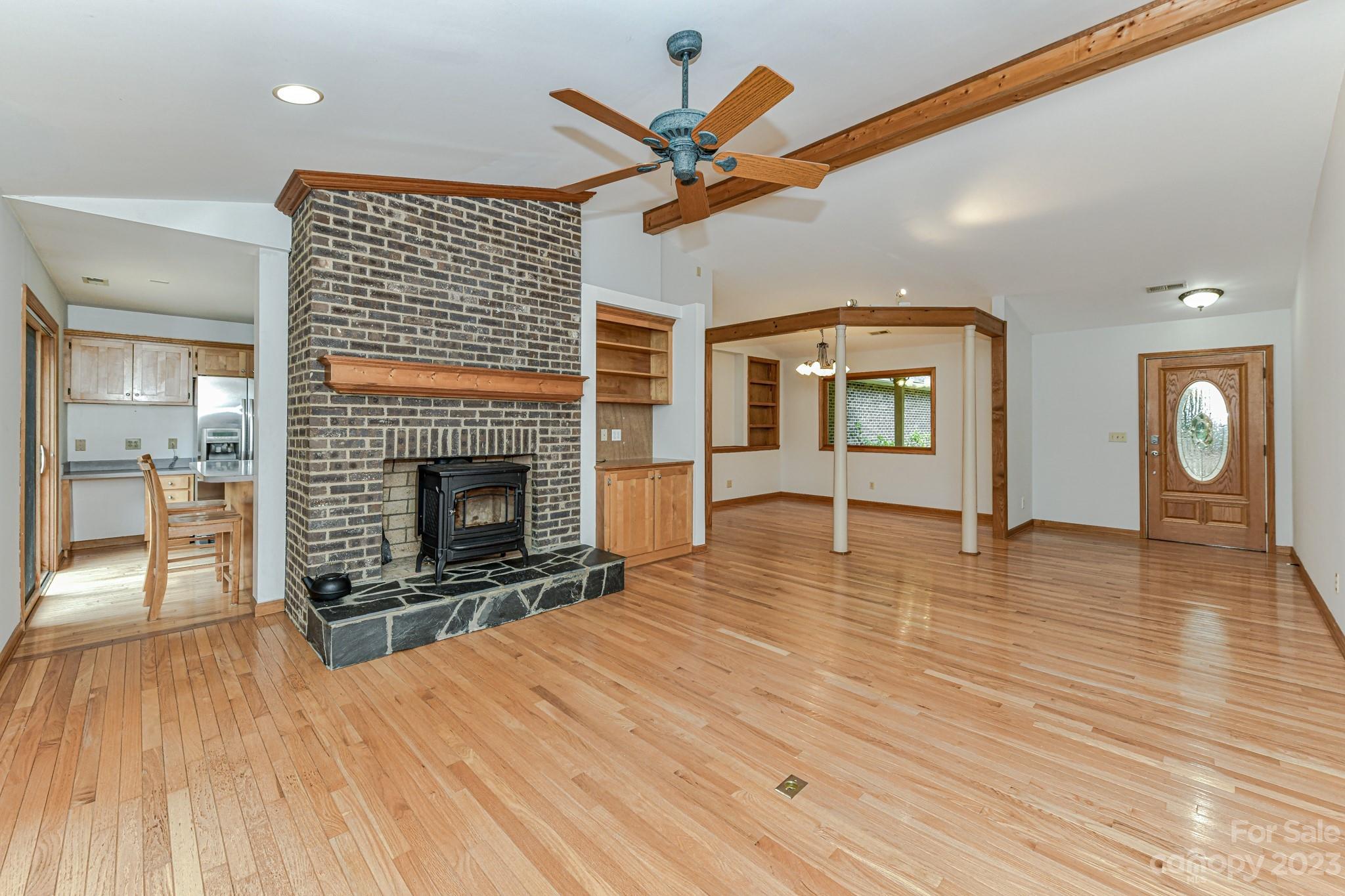 7911 Sims Road Waxhaw, NC 28173 - Photo 8 of 48 a view of a livingroom with a fireplace a ceiling fan and windows