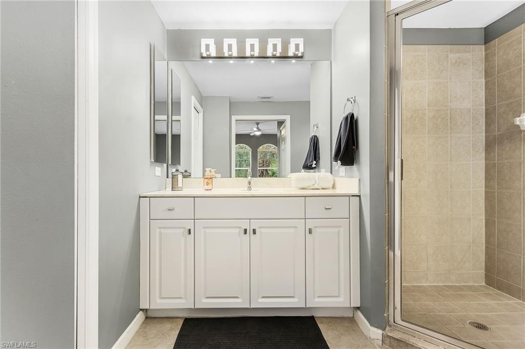 10045 Heather Lane, Unit 203 Naples, FL 34119 - Photo 14 of 30 a bathroom with a double vanity sink and a mirror