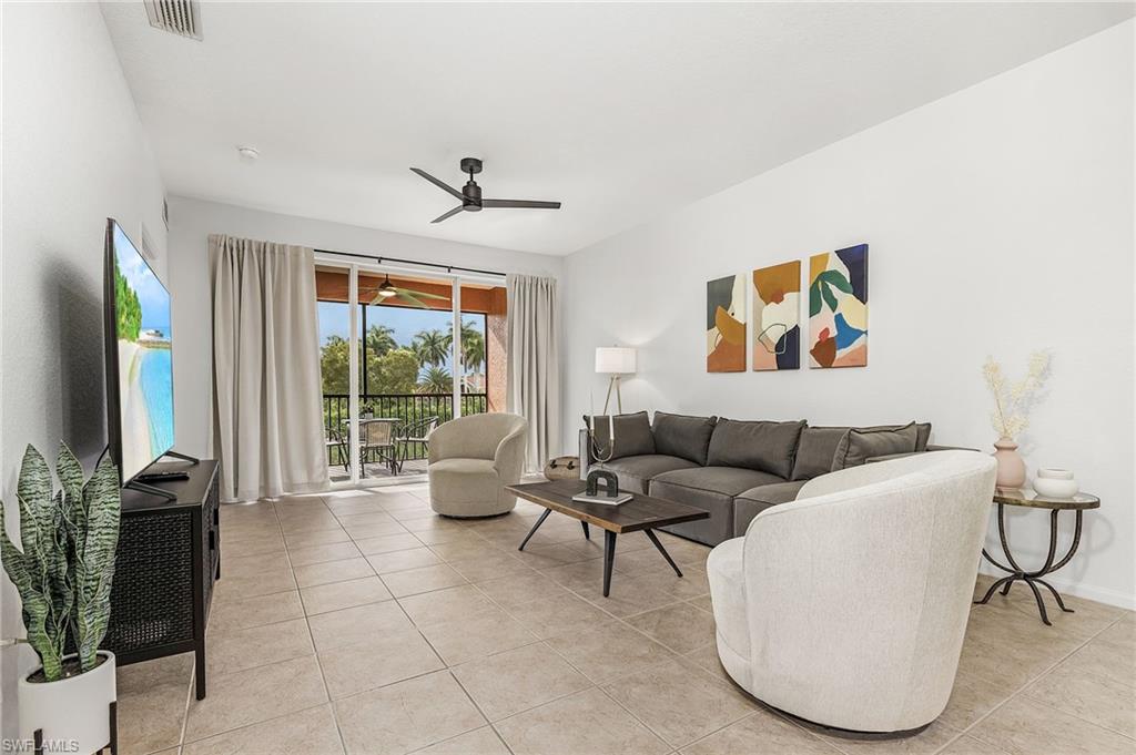 10045 Heather Lane, Unit 203 Naples, FL 34119 - Photo 7 of 30 a living room with furniture a floor to ceiling window and potted plants