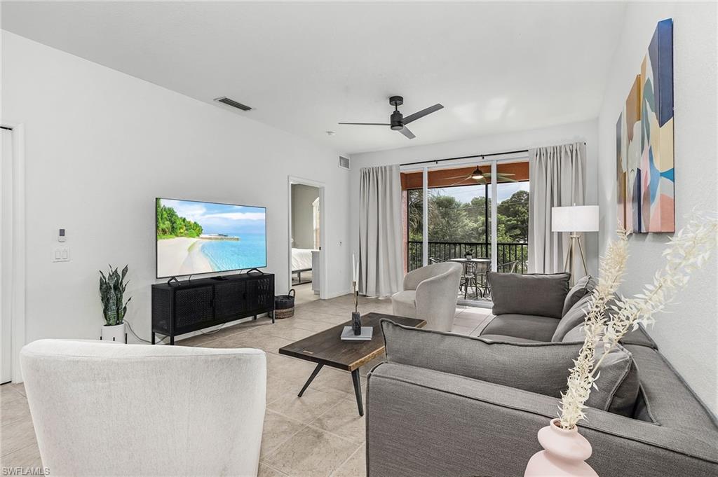 10045 Heather Lane, Unit 203 Naples, FL 34119 - Photo 8 of 30 a living room with furniture and a flat screen tv