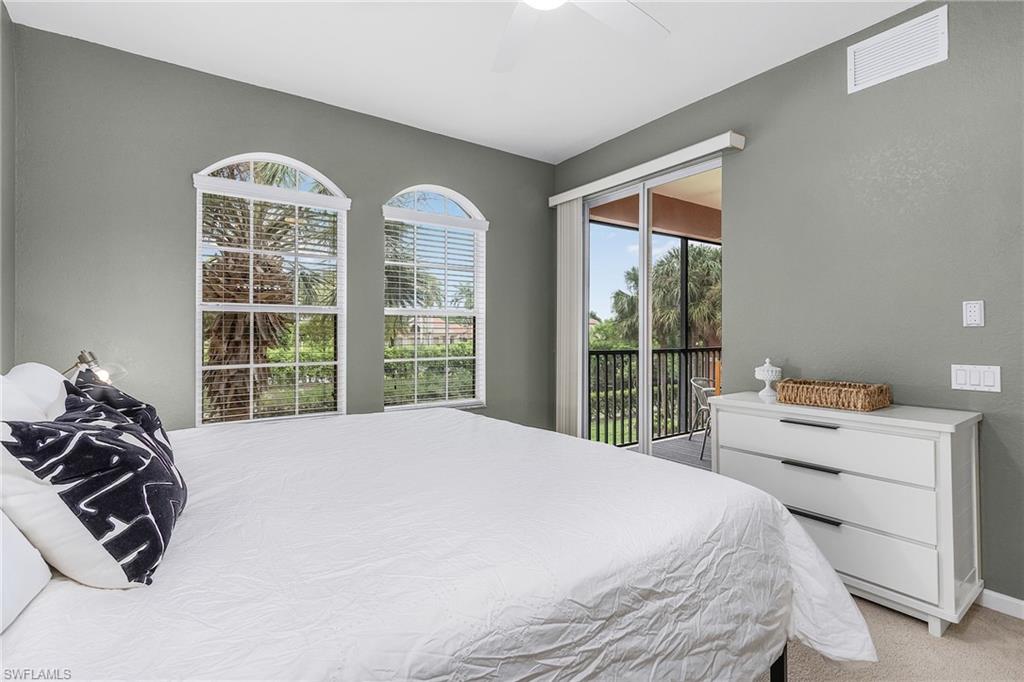 10045 Heather Lane, Unit 203 Naples, FL 34119 - Photo 9 of 30 a bedroom with a bed and a large window