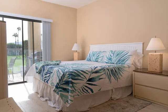 a bedroom with a bed and a large window