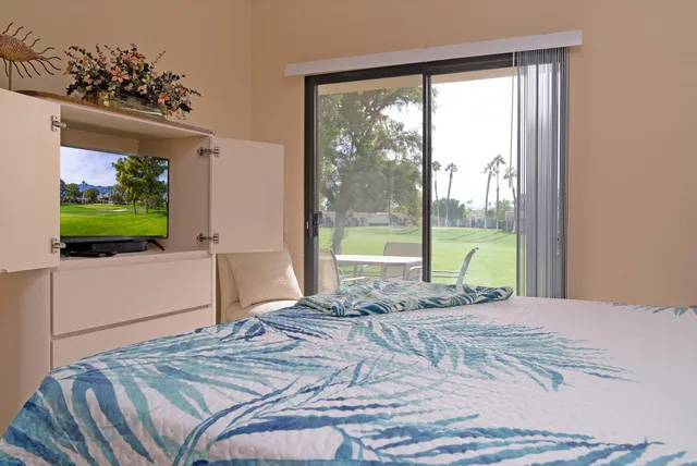 a bedroom with a bed and a flat screen tv
