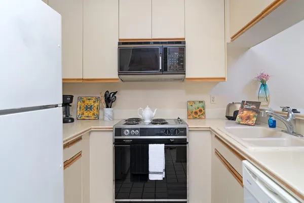 a kitchen with stainless steel appliances granite countertop a sink stove and microwave