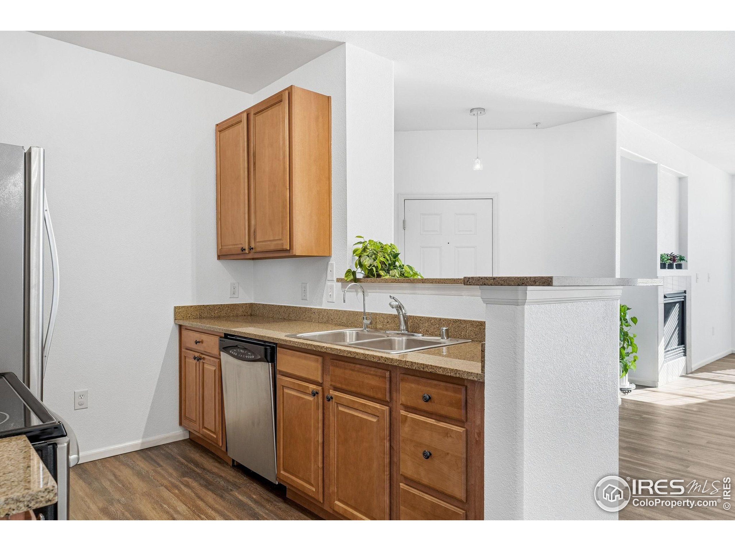 1425 Blue Sky Circle, Unit 15105 Erie, CO 80516 - Photo 14 of 45 a kitchen with a sink a window and wooden floor