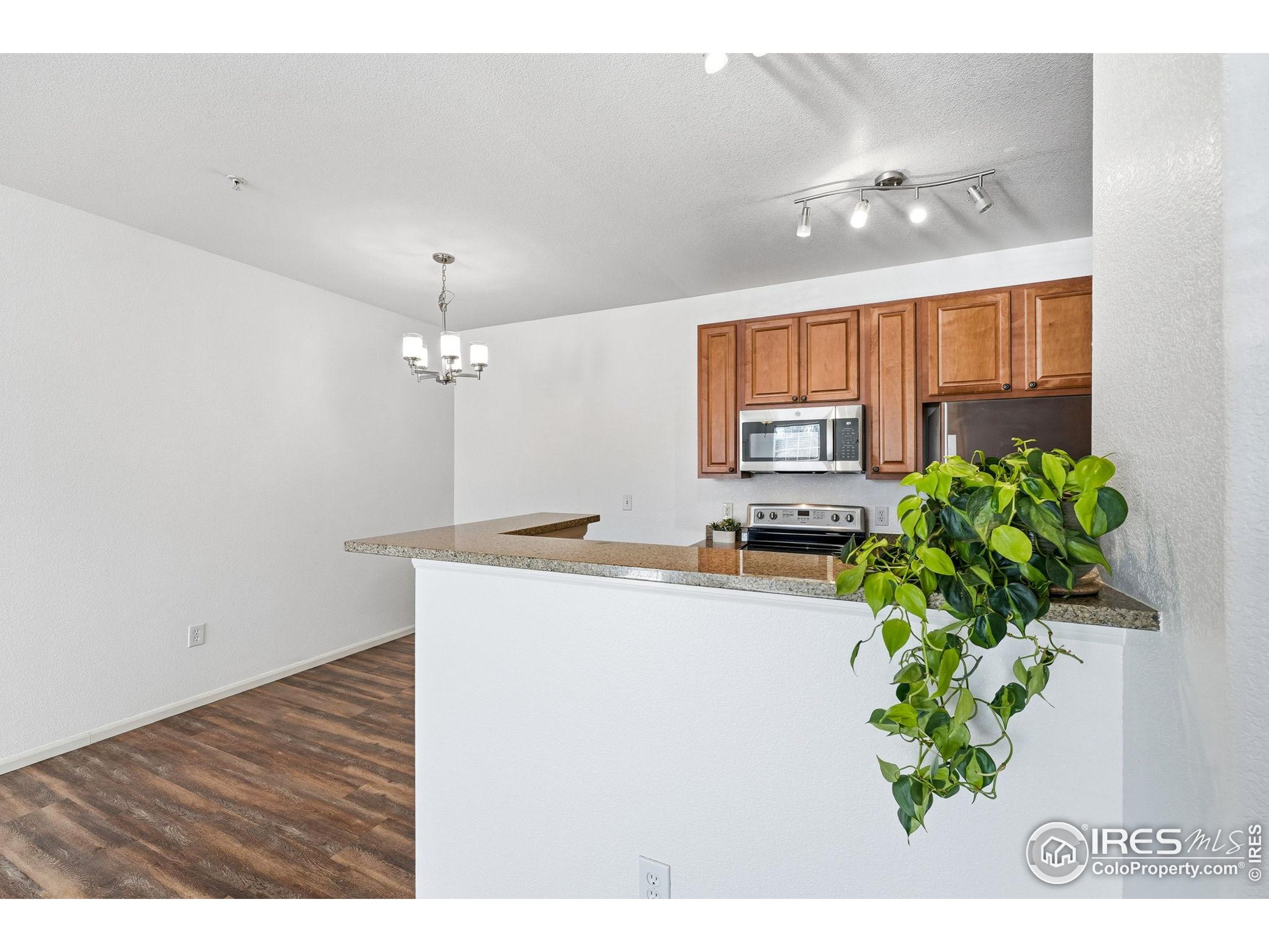 1425 Blue Sky Circle, Unit 15105 Erie, CO 80516 - Photo 15 of 45 a living room with kitchen island furniture and a chandelier