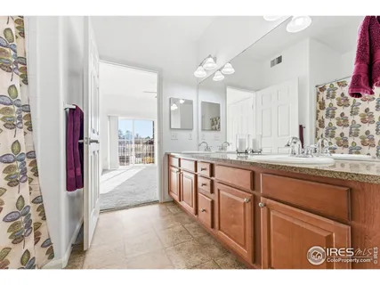 a bathroom with a granite countertop sink a mirror and shower