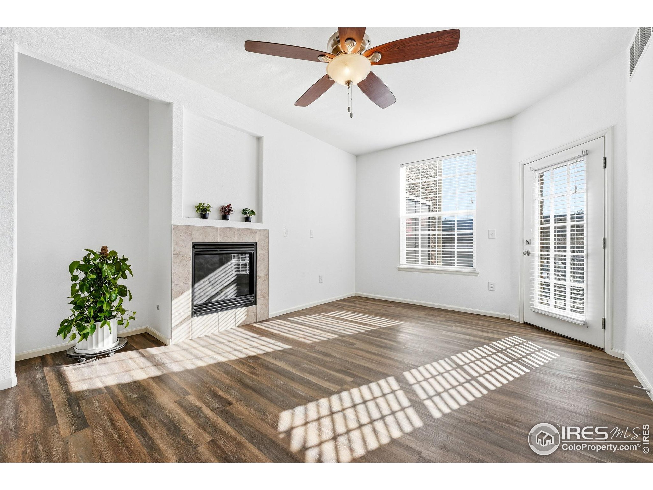 1425 Blue Sky Circle, Unit 15105 Erie, CO 80516 - Photo 3 of 45 a view of an empty room with window and wooden floor