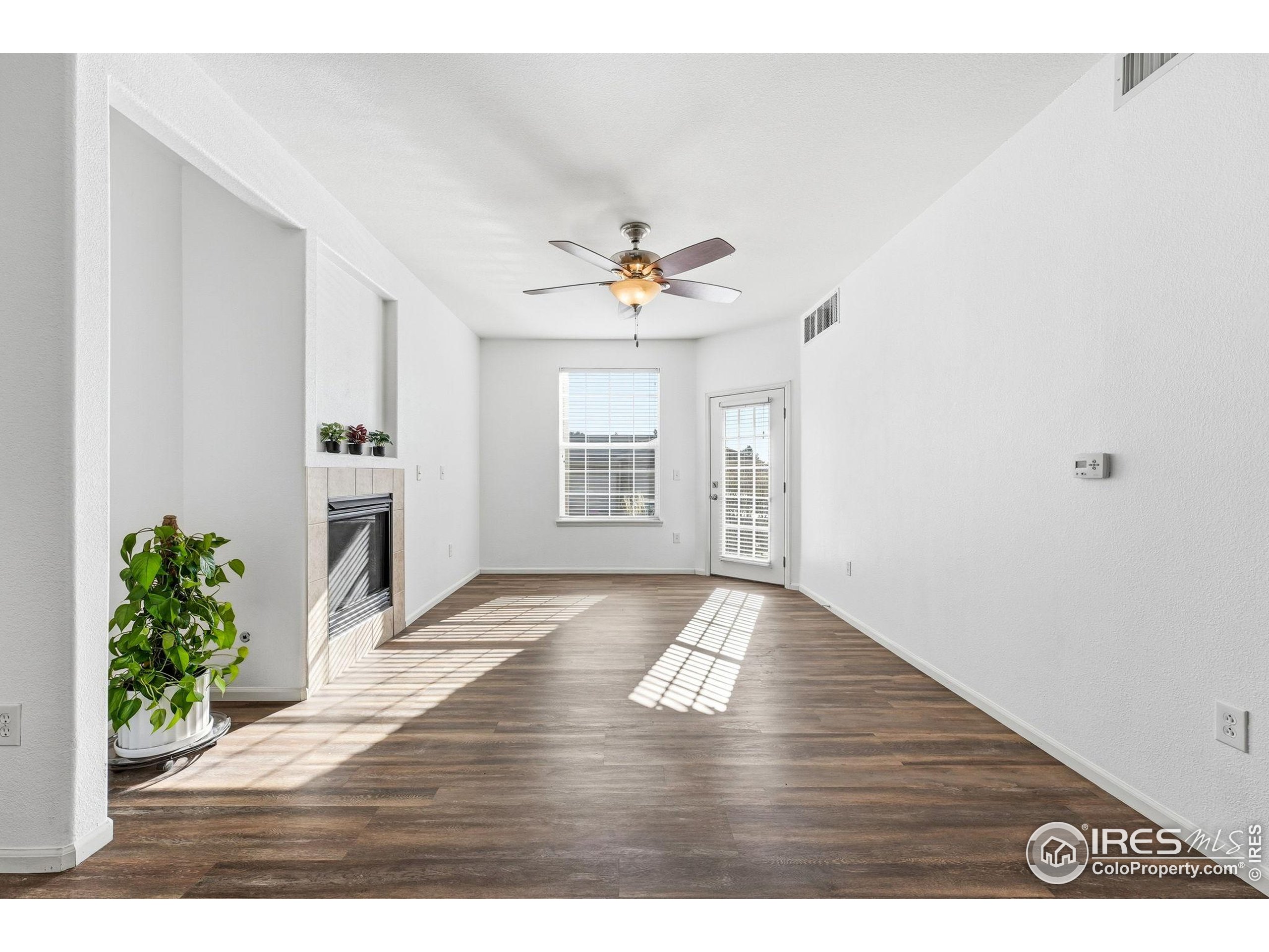 1425 Blue Sky Circle, Unit 15105 Erie, CO 80516 - Photo 5 of 45 a view of an empty room with wooden floor and a window