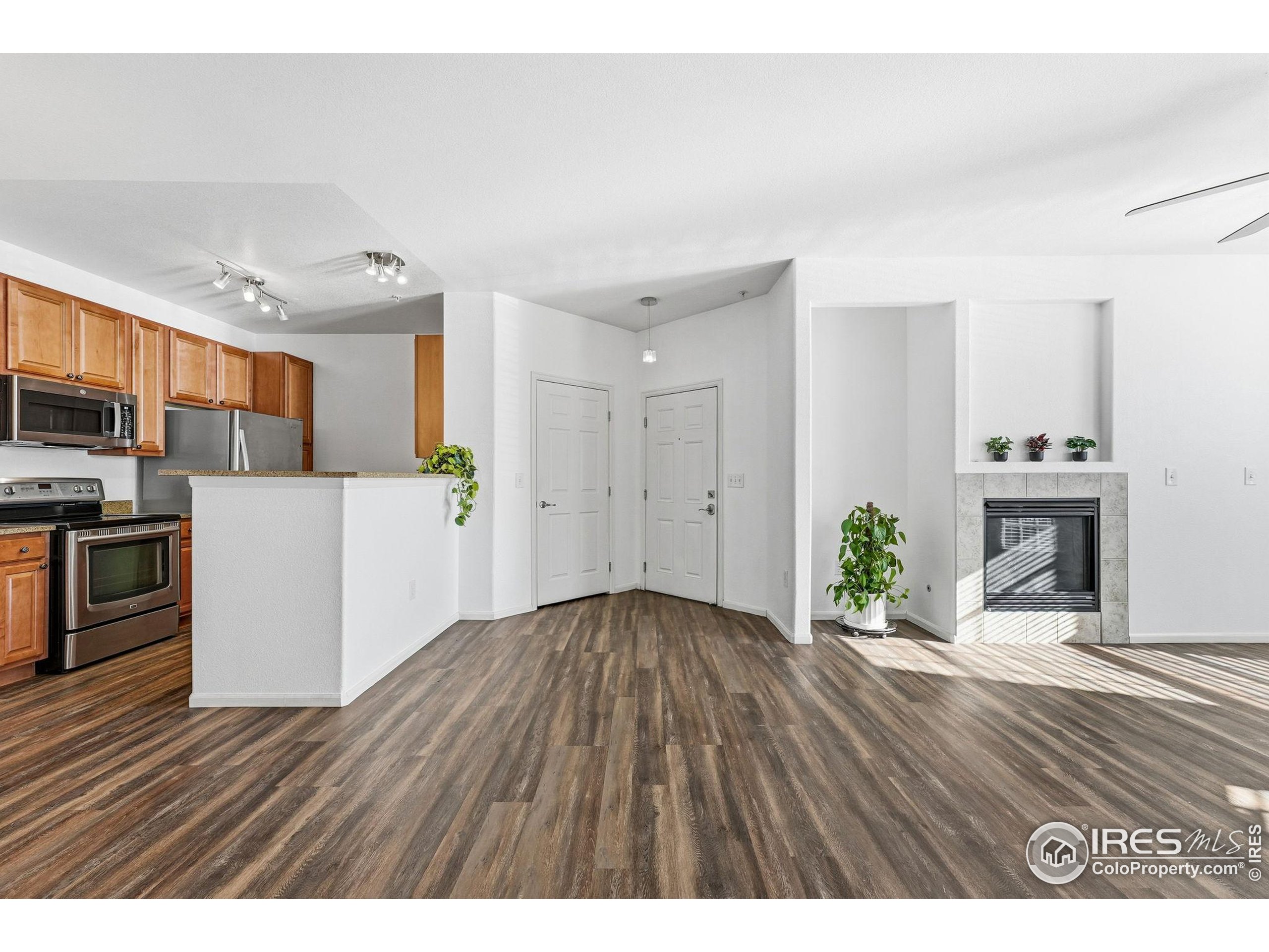 1425 Blue Sky Circle, Unit 15105 Erie, CO 80516 - Photo 6 of 45 a view interior of a house kitchen island granite countertop wooden floors and a fireplace