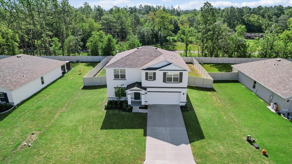 13691 Southwest 69th Terrace Ocala, FL 34473 - Photo 2 of 44 a aerial view of a house with a yard table and chairs
