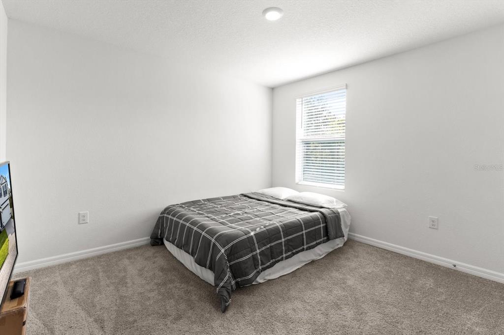 13691 Southwest 69th Terrace Ocala, FL 34473 - Photo 30 of 44 a bed sitting in a bedroom next to a window