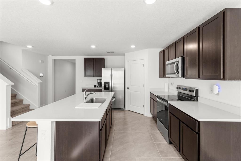 13691 Southwest 69th Terrace Ocala, FL 34473 - Photo 9 of 44 a kitchen with stainless steel appliances a sink stove and refrigerator