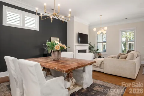 a living room with furniture a chandelier and a dining room