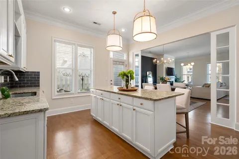 a kitchen with granite countertop a stove a sink a dining table and chairs