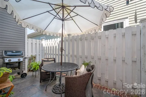 a backyard of a house with table and chairs