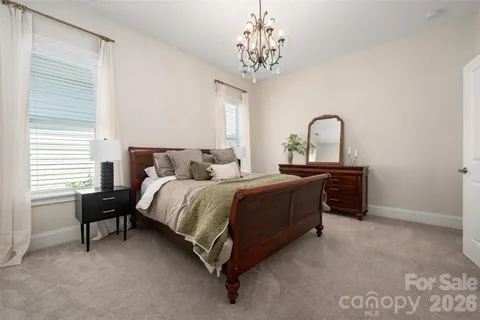 a bedroom with bed and a chandelier