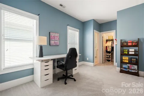 a view of a workspace with furniture and a window